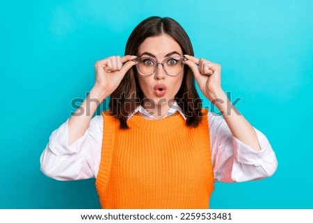 Photo of impressed astonished speechless woman bob hairstyle orange waistcoat arms touching glasses isolated on teal color background