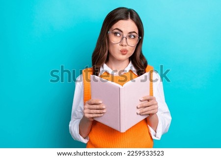 Photo of optimistic good mood cute woman with bob hairstyle orange waistcoat hold book look empty space isolated on teal color background