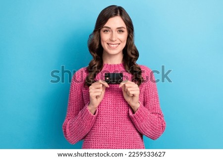Photo of adorable positive lady hand showing plastic bank card isolated on blue color background