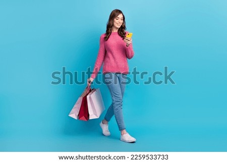 Full body size cadre of young girl optimist gadget usersmart phone e shopping black friday delivery bags boutique isolated on blue color background