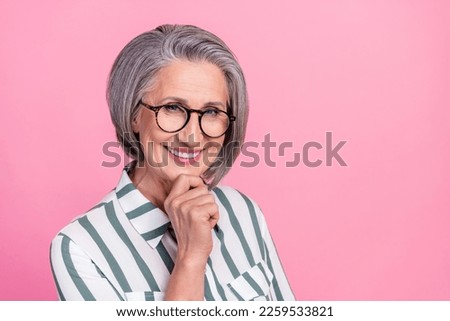 Portrait photo of cheerful positive smile pensioner attractive businesswoman touch chin wear glasses isolated on pastel pink color background