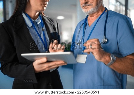 Young business woman shaking hand with elderly doctor. Royalty-Free Stock Photo #2259548591
