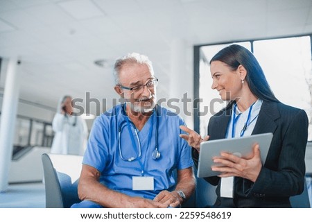 Young business woman shaking hand with elderly doctor. Royalty-Free Stock Photo #2259548619