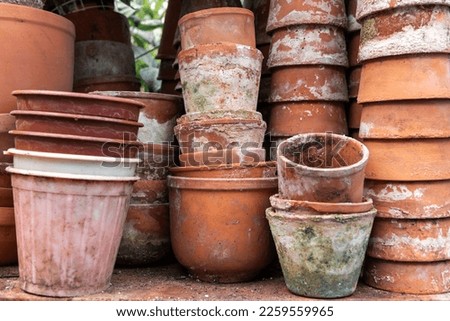 Clay pots. Stacks of old pots. ceramic dishes for flowers. Flower stock. Used items for recycling or reuse. Preparing garden tools.
