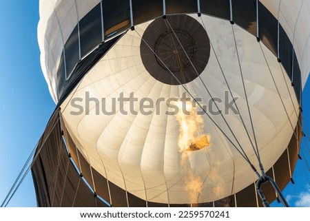 A view from below to the inside of the white, hot air balloon dome. Horizontal photo. Royalty-Free Stock Photo #2259570241