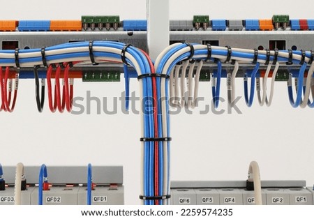 Connection of blocks and modules with an insulated wire on the reverse side of the electrical switchboard. Fastening with plastic mounting ties. Royalty-Free Stock Photo #2259574235