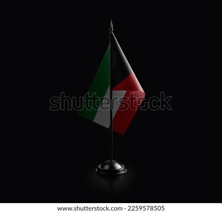 Small national flag of the Kuwait on a black background.