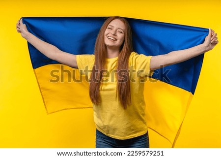 Happy woman with national Ukrainian flag on yellow. Ukraine, patriot, victory in war celebration, banner, Independence day. High quality photo