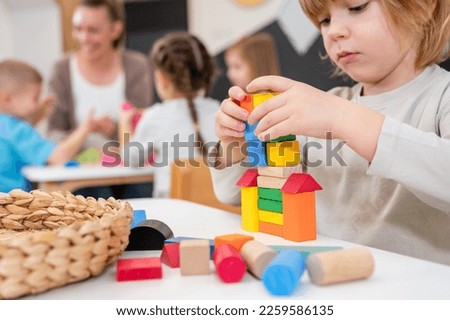 Kindergarten children playing with colorful building blocks. Healthy learning environment. Learning through play. Royalty-Free Stock Photo #2259586135