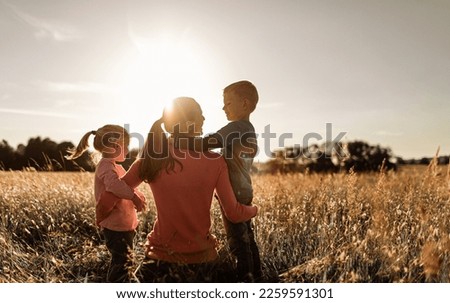 Happy single mother daughter son moment in nature sunset 