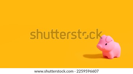 Rubber toy pig on a yellow background. Children's background. Children's toy. Banner. Copy space. Place for text.