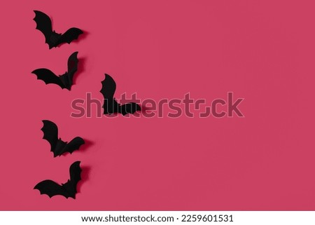 Cartoon halloween background black bats on orange backdrop. Bright holiday backdrop for your design in flat lay style with copy space.