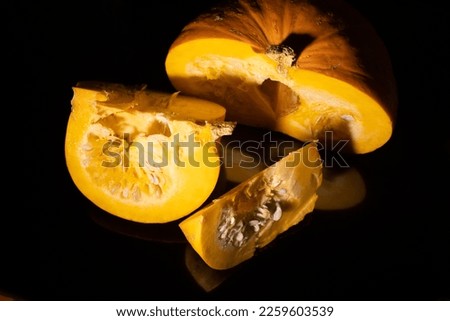 Yellow pumpkin sliced black background.