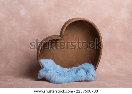 background texture empty space for baby with wooden heart and mattress. basket for a newborn photo shoot. heart made of wood, decorated with cute plush toys.