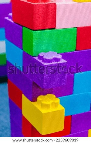 Background, texture, wall, from children's colored, multi-colored blocks, bricks on the playground for children's games. Closeup photo, concept of childhood and construction.