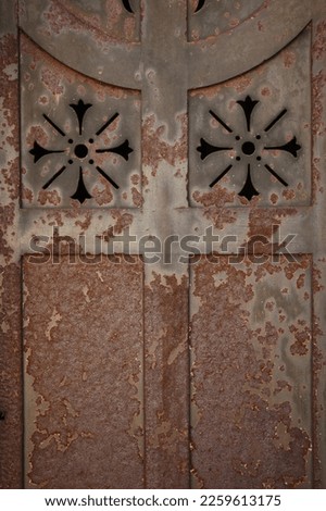 rusted metal doorway with two cross symbols
