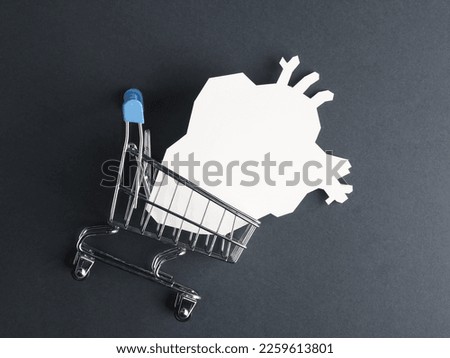 Shopping trolley with an anatomical heart on a gray background