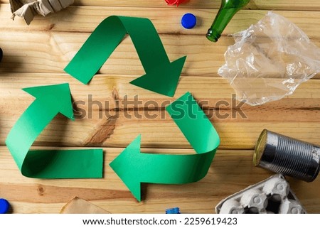 Close up of recycling symbol of paper green arrows and paper, plastic trash with copy space. Global ecology and recycling concept.