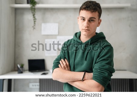 one man teenager stand in room at home wear green hoodie waist up Royalty-Free Stock Photo #2259622021