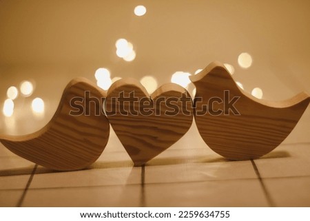  two wooden birds and heart made by bokeh lights background. Valentines day, Wedding, Easter card with wooden figures of birds, home decor
