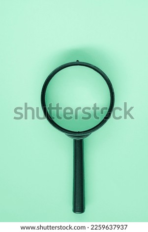 Magnifying glass isolated on green background. Selective focus
