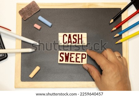Business and finance concept. On a white surface are twisted dollars, a notebook and a cardboard sign with the inscription - Cash sweep