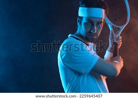 Tennis player in white clothes on a black background with smoke. Download a photo for advertising tennis in a magazine, in the news on the website, on the billboard in social networks.