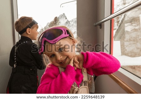 Little girl looking to camera in train during travel on cogwheel Royalty-Free Stock Photo #2259648139