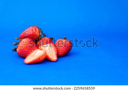 Ripe and fresh strawberries on blue background.