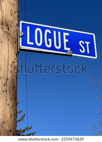 Logue St. street sign on telephone pole with deep blue sky backdrop.