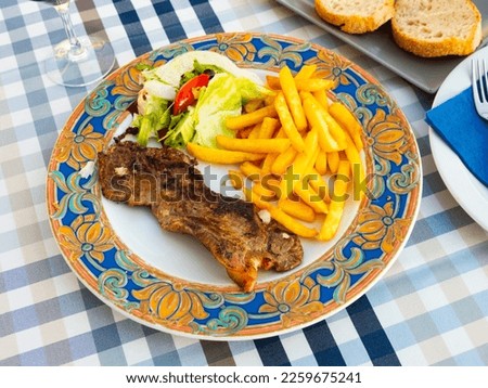 Medium roast entrecote garnished with salad of fresh vegetables, decorated with cottage cheese Royalty-Free Stock Photo #2259675241