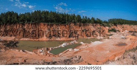Panorama of a quarried land with green waters at Milton, Florida. Mine quarry with puddles of green waters and views of trees across against the sky. Royalty-Free Stock Photo #2259695501