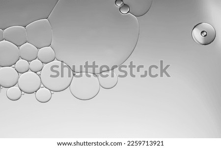 Oil bubbles droplets droplets created pattern and an art image on silver grey gradient light effects background. Ideal for wallpaper, templates, advertising etc., 