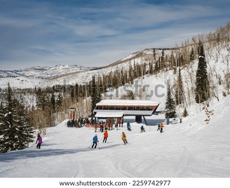 Beautiful view of skiers and snowboarders going down to chairlift on nice day in Colorado ski resort in winter; sky in background
 Royalty-Free Stock Photo #2259742977