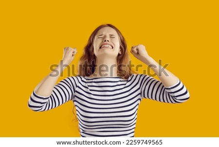 Desperate woman gets angry and cries out of despair, not knowing how to improve situation. Young caucasian woman in despair waving her hands on orange background. People and frustration concept.