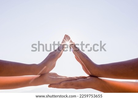 Hands of family members forming house shaped sunset sky background