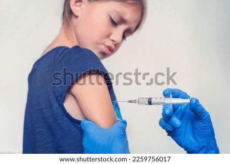 The child is afraid of a syringe, the girl yells and does not want to give an injection. Children's fear of medical procedures. Vakination. Girl afraid of injections at the doctor's office Royalty-Free Stock Photo #2259756017