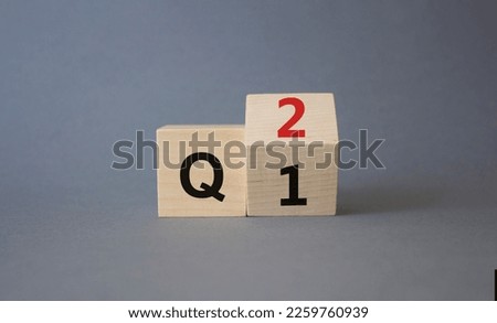 From 1st Quarter to 2nd symbol. Turned wooden cubes with words 1st Quarter and 2nd Quarter. Beautiful grey background. Business and Quarter concept. Copy space Royalty-Free Stock Photo #2259760939
