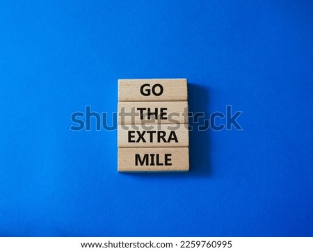 Go the extra mile symbol. Wooden blocks with words Go the extra mile. Beautiful blue background. Business and Go the extra mile concept. Copy space.