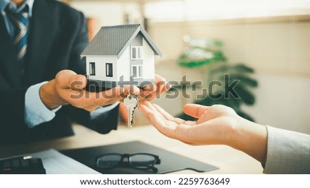 Real estate sales-rental agents provide keys and house models to clients. After discussing the documents and signing the contract to complete the contract legally