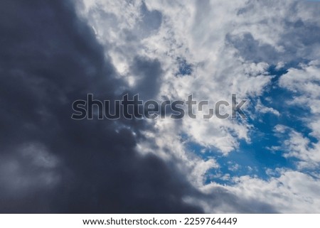 Summer cloudy dramatic rainy sky background with sun rays. Panoramic view with beautiful clouds. Horizontal cloudscape. High-resolution photography. Design element. Copy space. 