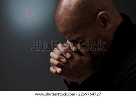 man praying to god with hands together Caribbean man praying with black background with people stock photo Royalty-Free Stock Photo #2259764727