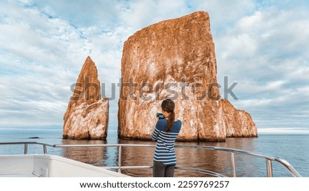 Galapagos Islands Cruise ship tourist taking pictures of Kicker Rock nature landscape. Iconic landmark and tourist destination for birdwatching, diving and snorkeling, San Cristobal Island, Galapagos