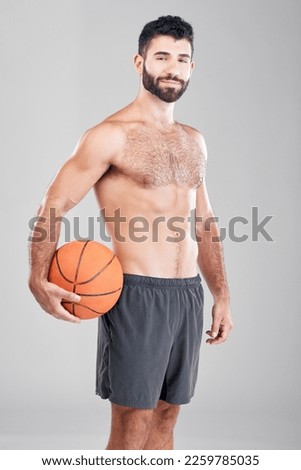 Sport, fitness and portrait of man with basketball and smile, topless and isolated on grey background. Exercise, motivation and ball sports coach or personal trainer with workout mindset in studio.