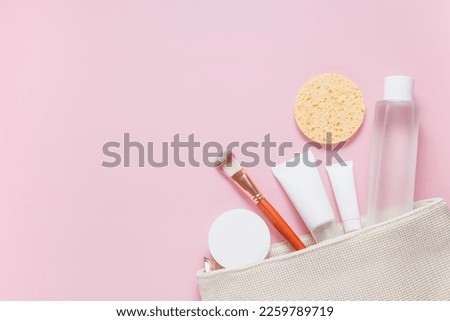 Set of cosmetic products for face care in white color on a pink background. Beauty. Self care. Moisturizing the skin of the face. Cream, face mask, toner, facial brush, sponge. Place for text.