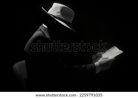 Faceless Man Wearing Hat and Reading The Holy Bible Royalty-Free Stock Photo #2259791035