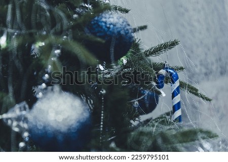 Defocused blurred close up of blue and silver glass toys on Christmas tree with bokeh