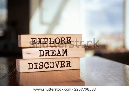 Wooden blocks with words 'Explore, dream, discover'. Motivational quote