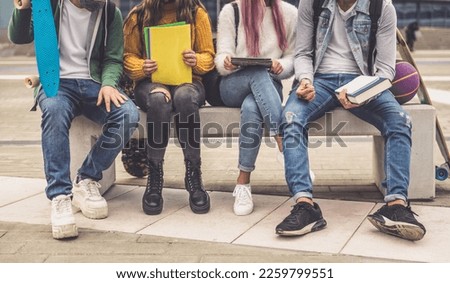 Group of teenagers making activities after school. Multiethnic boys and girl studying outdoor. Royalty-Free Stock Photo #2259799551