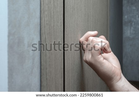 Knock on the village door. The young man knocks on the door. A man's finger knocks on the door. Visit to friends Royalty-Free Stock Photo #2259800861